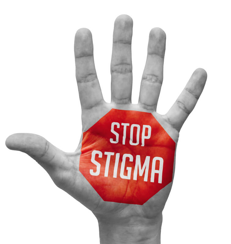 Red sign painted on open hand with words stop stigma